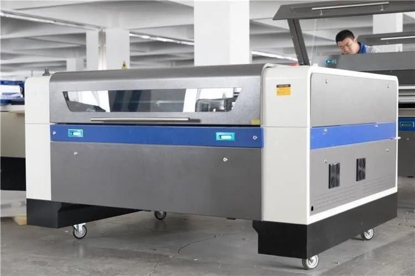CO2 laser cutter cabinet on casters with the lid closed, standing on a factory floor