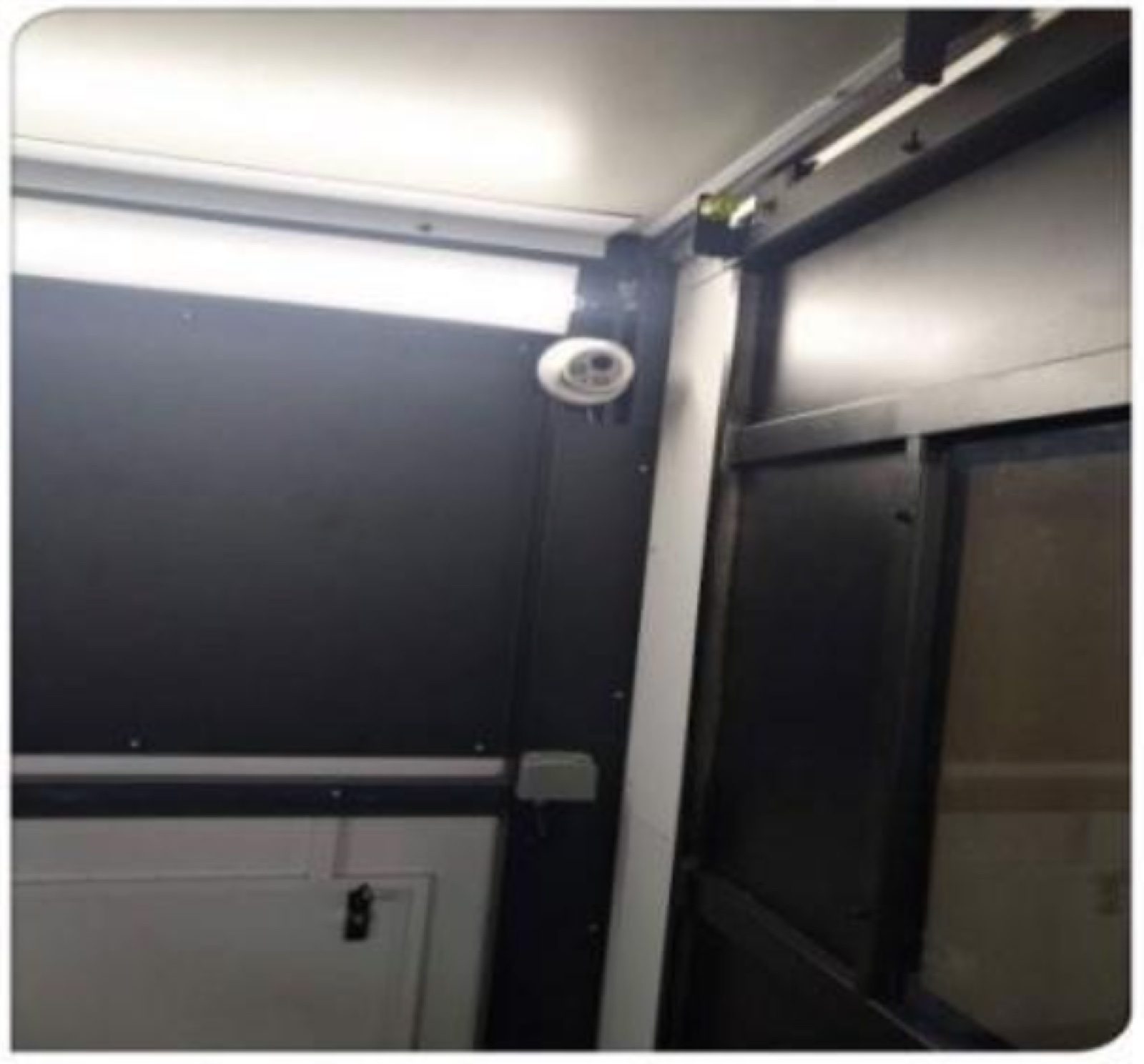 Dome camera mounted high on the wall inside the enclosure of the fiber laser cutter